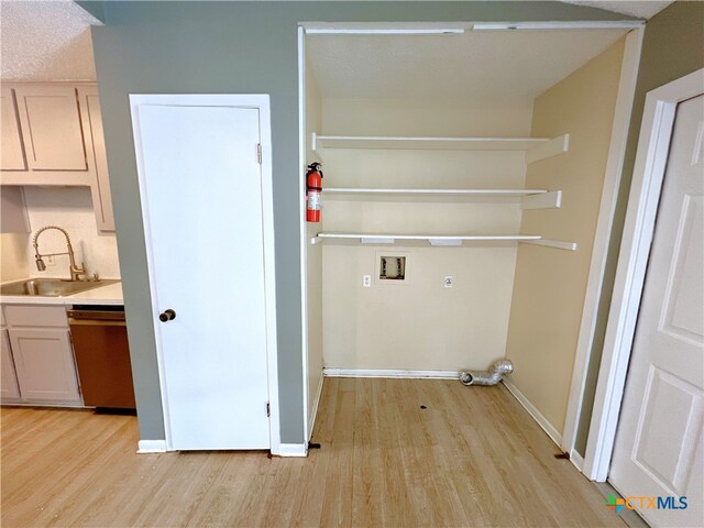 105 Kensington Dr, Victoria, TX 77901 - laundry room featuring washer hookup, light wood finished floors, electric dryer hookup, and baseboards