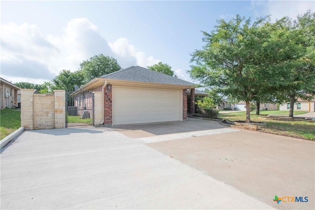 4700 Aurora Cir, Killeen, TX 76542 - view of side of property with brick siding, a gate, a detached garage, and roof with shingles