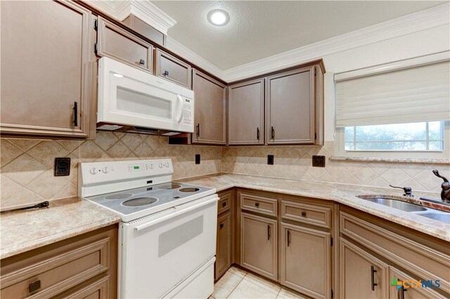 4700 Aurora Cir, Killeen, TX 76542 - kitchen with white appliances, ornamental molding, a sink, tasteful backsplash, and light tile patterned floors