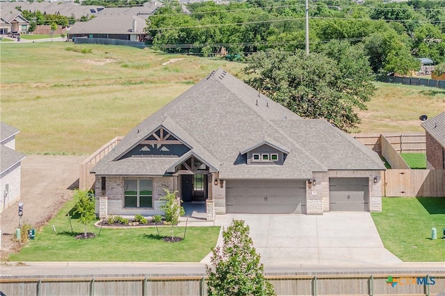 711 Saddlehorn Dr, Temple, TX 76502 - view of front of property with driveway, stone siding, a shingled roof, brick siding, and a garage
