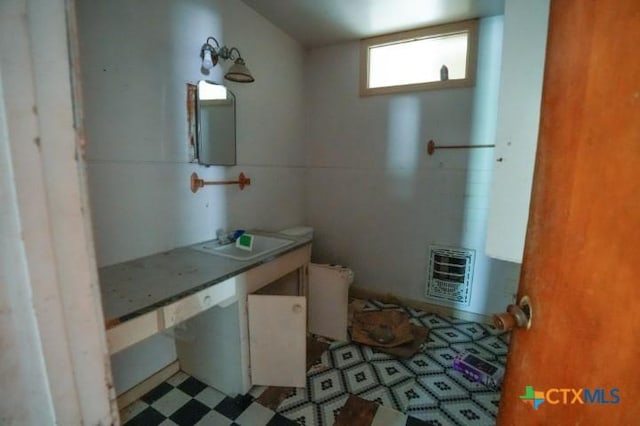 626 E Wallace St, Gonzales, TX 78629 - half bath featuring heating unit, vanity, and tile patterned floors