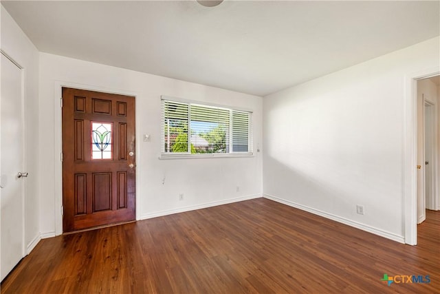 foyer entrance with dark wood-style floors and baseboards