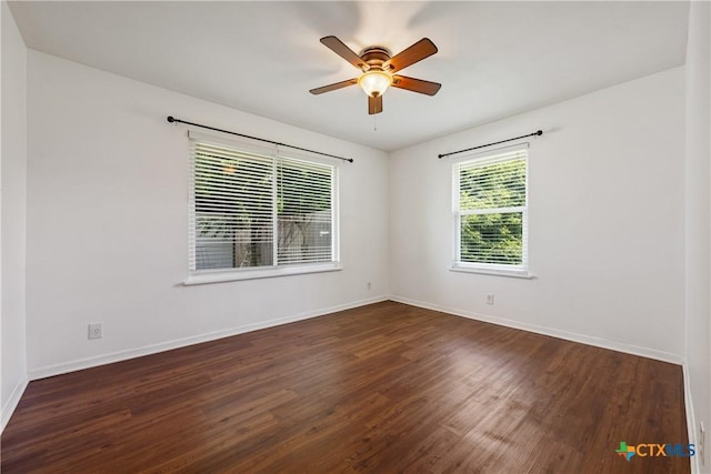 unfurnished room with dark wood-style floors, a ceiling fan, and baseboards