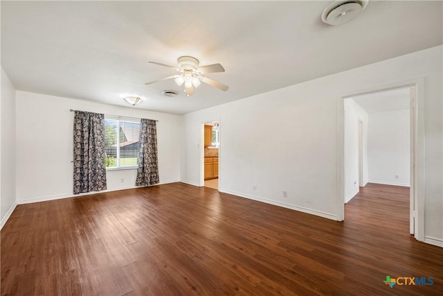 unfurnished room featuring dark wood-style floors, ceiling fan, and baseboards