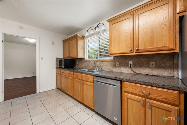 kitchen featuring light tile patterned floors, decorative backsplash, brown cabinets, stainless steel dishwasher, and a sink