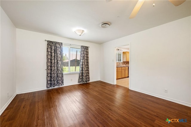 spare room featuring ceiling fan, wood finished floors, and baseboards