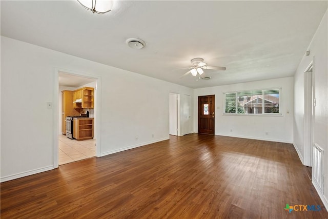 unfurnished living room with a ceiling fan, light wood-style flooring, and baseboards