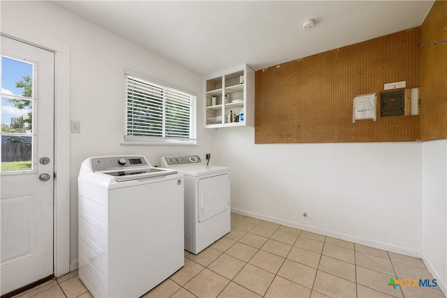 clothes washing area featuring laundry area, light tile patterned floors, baseboards, and separate washer and dryer