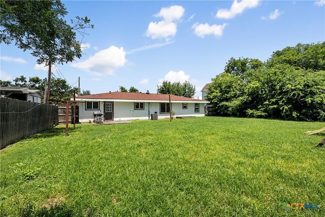 rear view of property with a lawn and fence