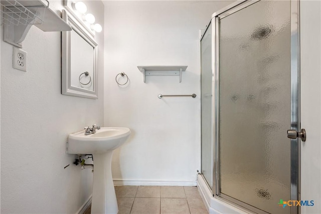 bathroom featuring a shower stall, a sink, and tile patterned floors