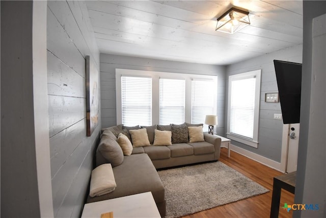 living room with wood finished floors and wood walls