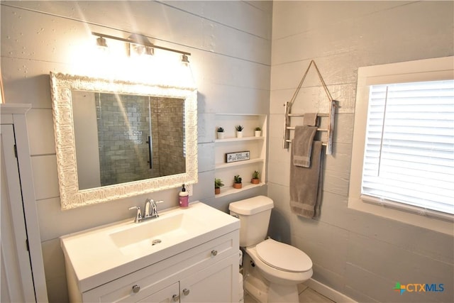 full bathroom with a tile shower, toilet, and vanity