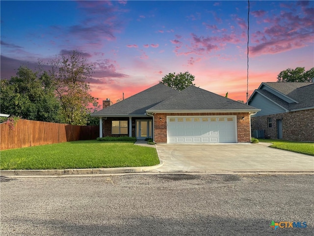 view of front of property featuring a lawn and a garage