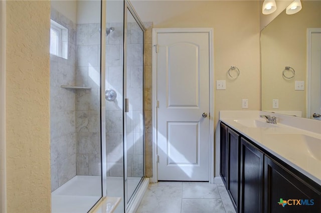 bathroom with vanity, a shower with shower door, and tile patterned floors