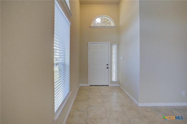 tiled foyer with a towering ceiling