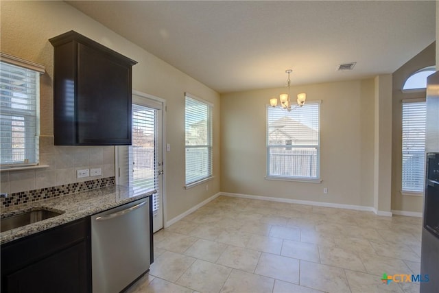 kitchen with light stone countertops, dishwasher, light tile patterned floors, sink, and backsplash