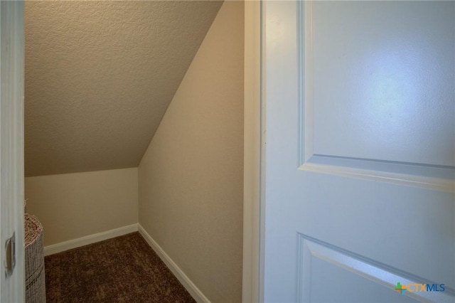 interior space featuring carpet floors and vaulted ceiling