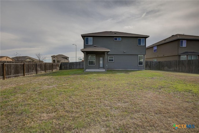 back of house featuring a lawn