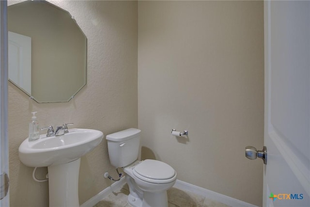 bathroom featuring sink, tile patterned floors, and toilet