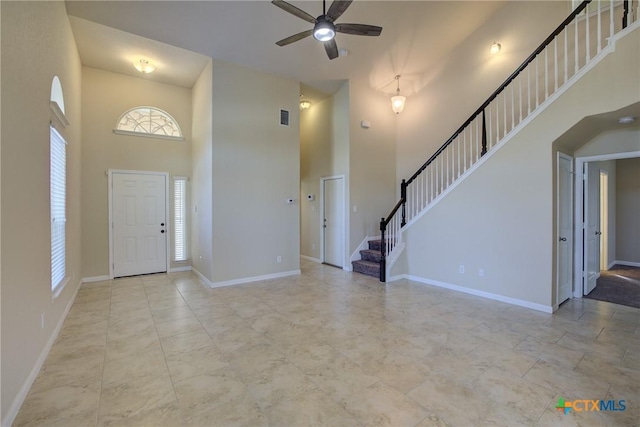 foyer with ceiling fan and a high ceiling