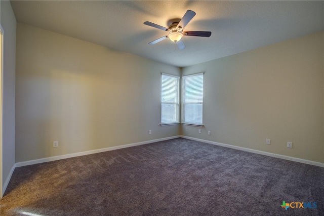 spare room with ceiling fan and dark carpet