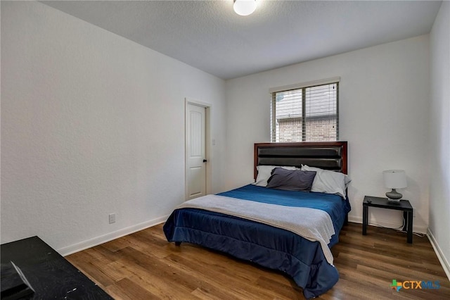 bedroom with dark wood-type flooring and a textured ceiling