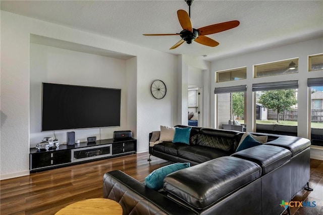 living room featuring ceiling fan, dark hardwood / wood-style flooring, and a textured ceiling