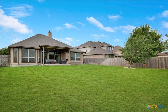 rear view of property with a yard and a patio