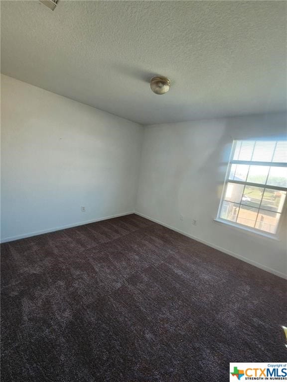 carpeted spare room with a textured ceiling