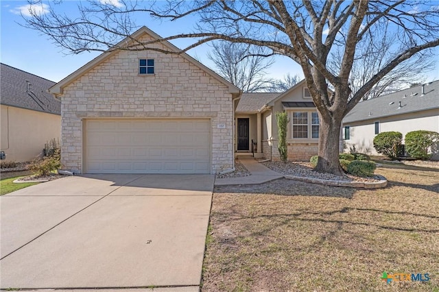 view of front of home featuring an attached garage, stone siding, and driveway