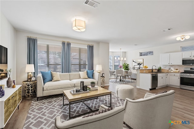 living area with visible vents and light wood-style floors