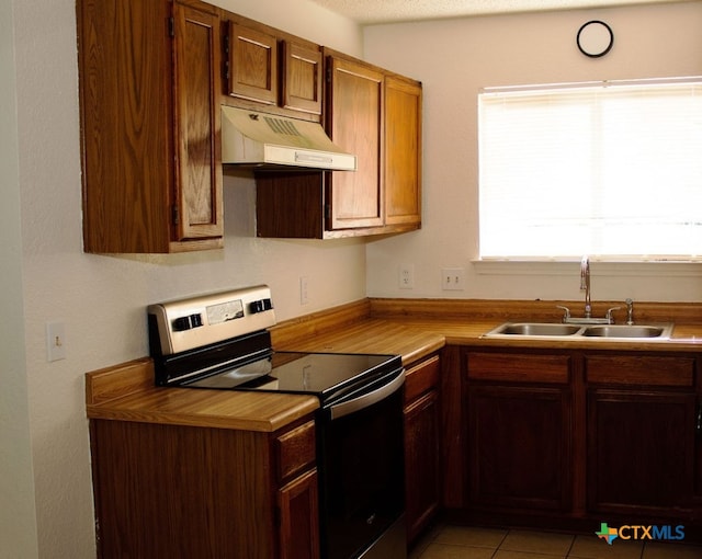 kitchen featuring a textured ceiling, electric stove, sink, and light tile patterned floors