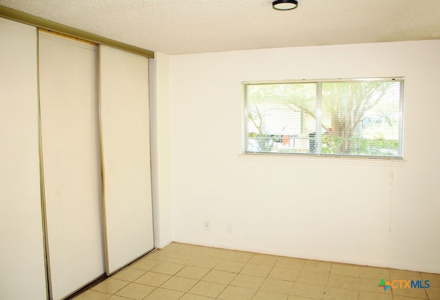 unfurnished bedroom with light tile patterned floors and a textured ceiling