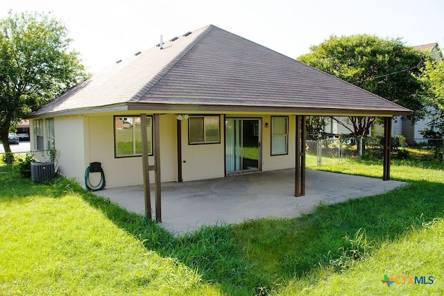 rear view of house with a lawn, cooling unit, and a patio