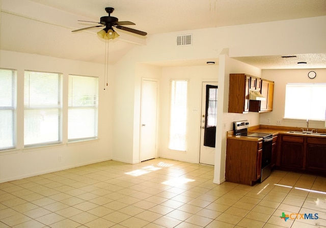 kitchen with stainless steel electric stove, sink, vaulted ceiling with beams, ceiling fan, and light tile patterned flooring