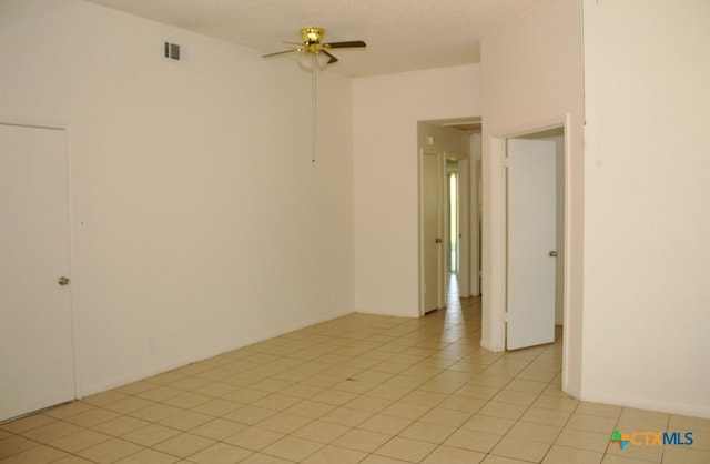 empty room with light tile patterned floors and ceiling fan