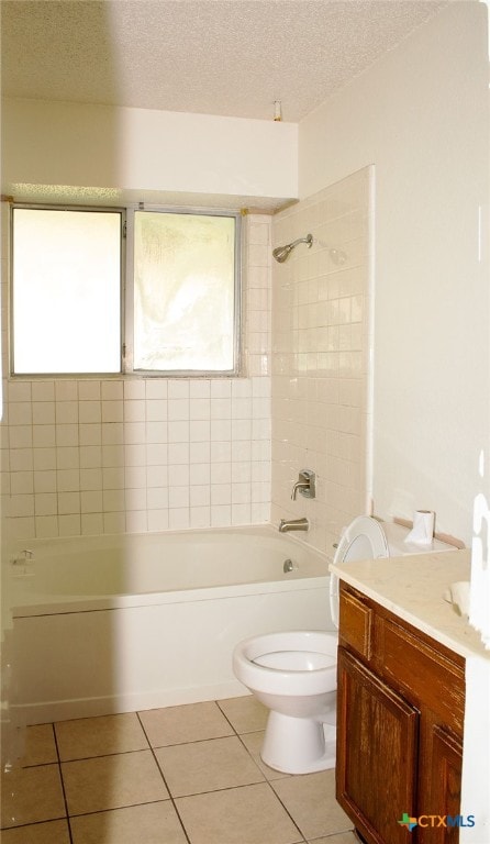 full bathroom with vanity, tile patterned floors, tiled shower / bath, toilet, and a textured ceiling