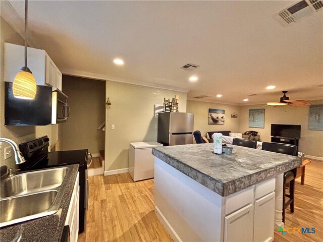1306 W Madison Ave, Port Oconnor, TX 77982 - kitchen with appliances with stainless steel finishes, a sink, light wood-type flooring, ceiling fan, and recessed lighting