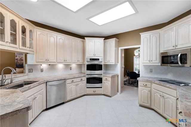 110 Agua Verde, Seguin, TX 78155 - kitchen with stainless steel appliances, a sink, light countertops, glass insert cabinets, and decorative backsplash