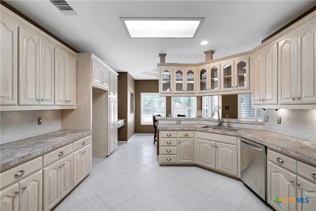 110 Agua Verde, Seguin, TX 78155 - kitchen featuring stainless steel dishwasher, a sink, a peninsula, glass insert cabinets, and healthy amount of natural light