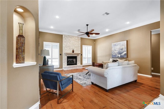 110 Agua Verde, Seguin, TX 78155 - living room featuring ceiling fan, crown molding, light wood finished floors, a stone fireplace, and recessed lighting