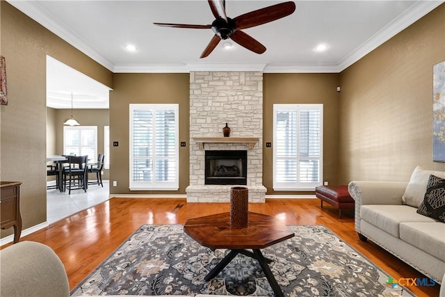 110 Agua Verde, Seguin, TX 78155 - living area featuring ceiling fan, wood finished floors, a fireplace, crown molding, and baseboards
