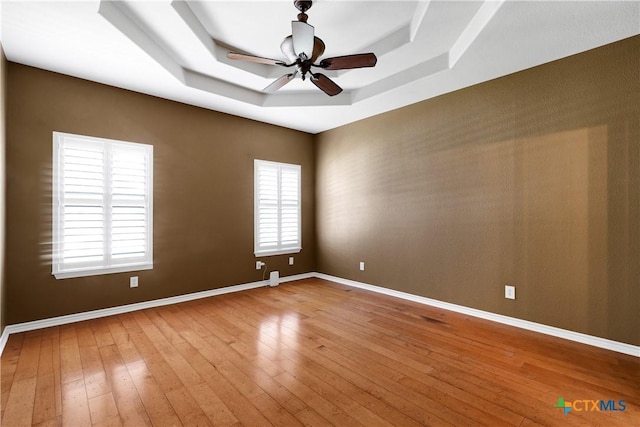 110 Agua Verde, Seguin, TX 78155 - empty room with a raised ceiling, wood-type flooring, ceiling fan, and baseboards