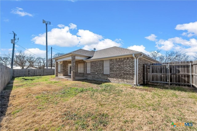 rear view of property featuring a lawn