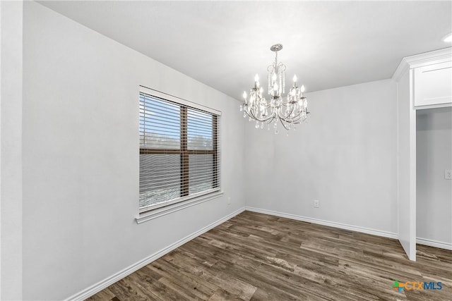 unfurnished dining area featuring an inviting chandelier and dark hardwood / wood-style flooring