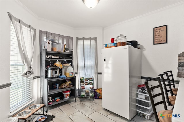 interior space featuring freestanding refrigerator, crown molding, and tile patterned flooring