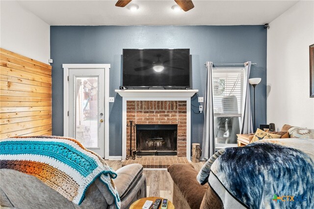 bedroom with access to exterior, wood finished floors, a fireplace, and ceiling fan