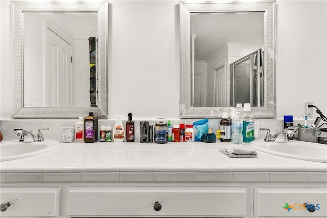 bathroom featuring double vanity and a shower stall