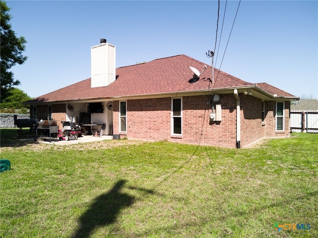 rear view of property with a patio area, a chimney, brick siding, and roof with shingles