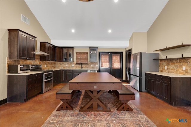 kitchen with decorative backsplash, appliances with stainless steel finishes, concrete floors, and dark brown cabinets